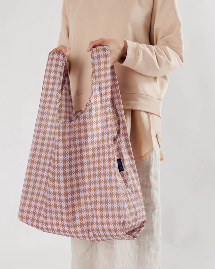 Close-up of Standard BAGGU being held up by handles to show size